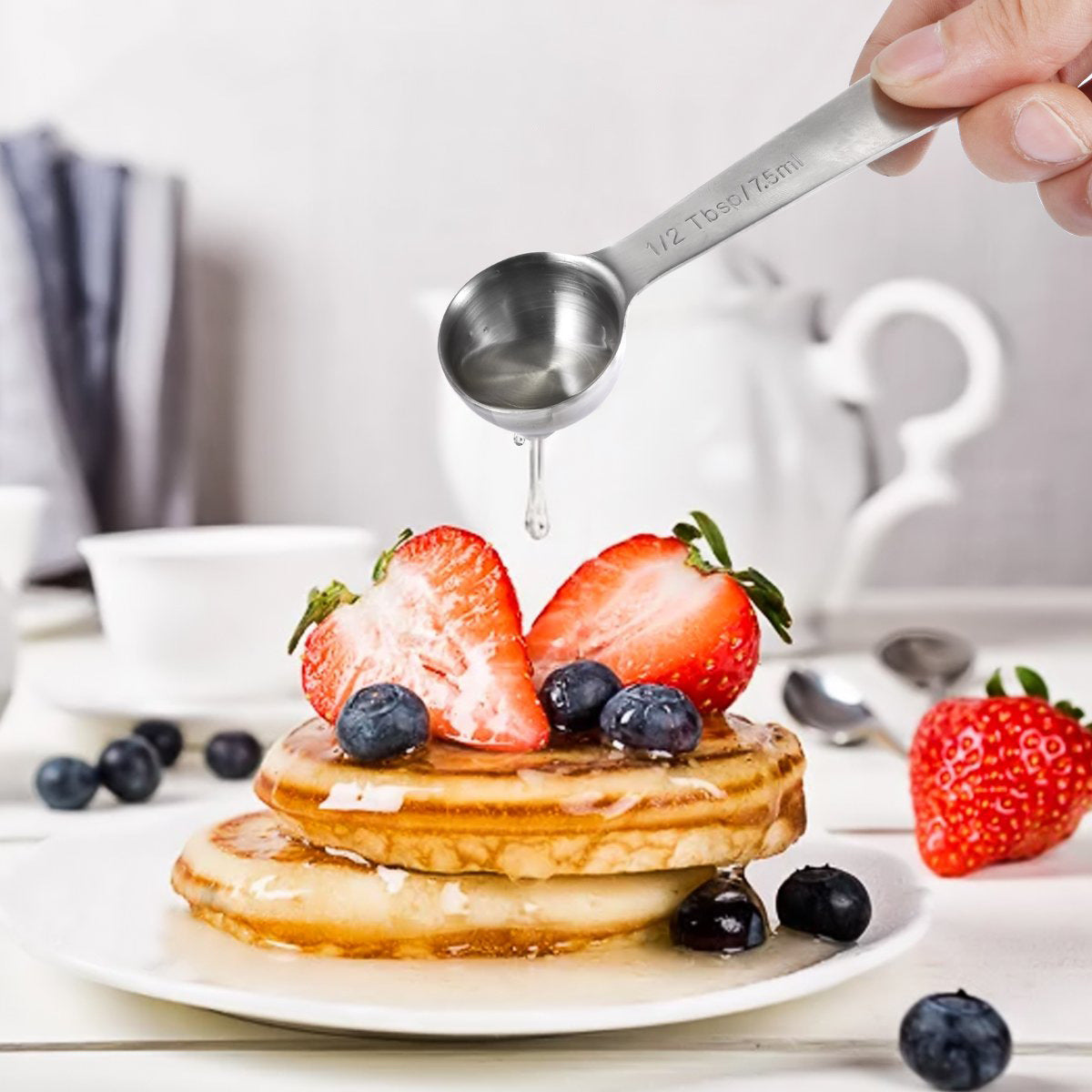 Stainless Steel Measuring Cup and Measuring Spoon 14-piece Set used to pour syrup over pancakes topped with strawberries and blueberries.Stainless Steel Measuring Cup and Measuring Spoon 14-piece Set
